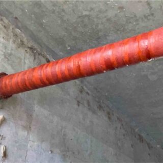 Orange pipe against concrete wall
