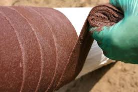 Gloved hand holding construction fabric